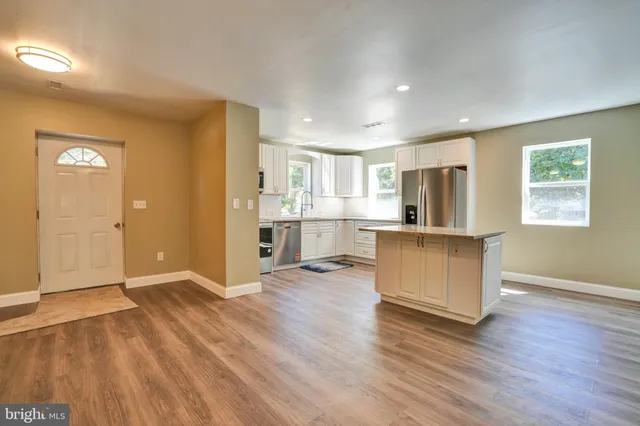 a view of a kitchen with wooden floor and electronic appliances