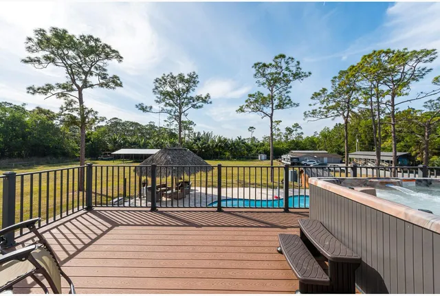 a balcony with wooden floor table and chairs
