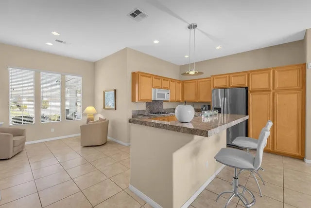 a kitchen with stainless steel appliances granite countertop a refrigerator and a stove top oven