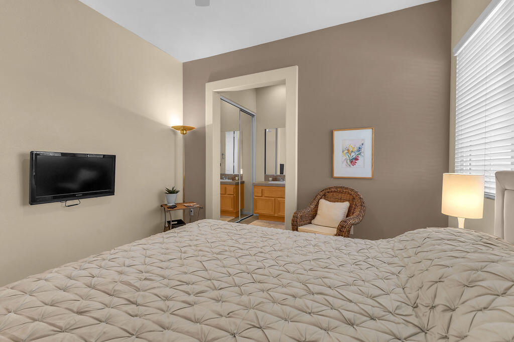29 Calle La Reina Rancho Mirage, CA 92270 - Photo 33 of 49 a bedroom with a bed and a flat screen tv