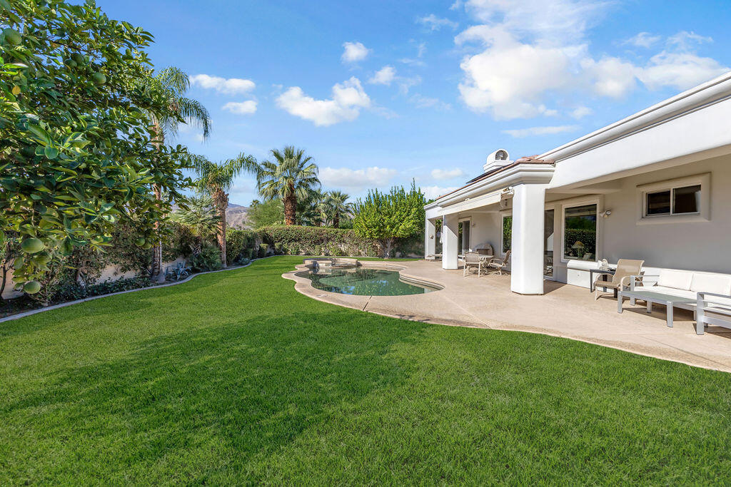 29 Calle La Reina Rancho Mirage, CA 92270 - Photo 42 of 49 a view of a patio with table and chairs with wooden fence