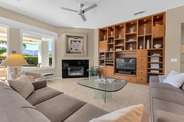 a living room with furniture a fireplace and a large window