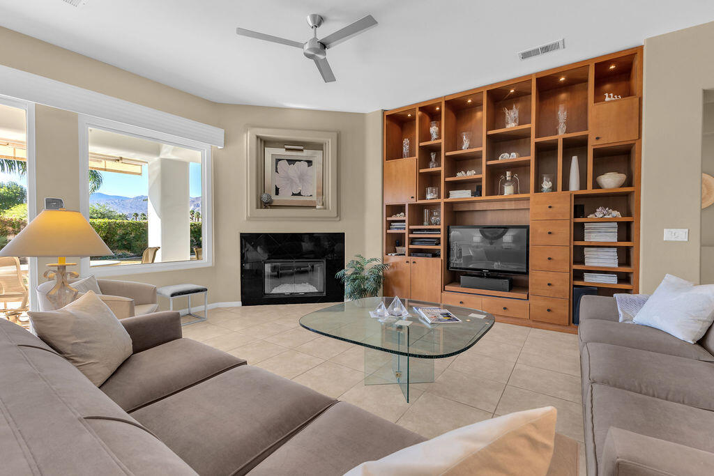 29 Calle La Reina Rancho Mirage, CA 92270 - Photo 8 of 49 a living room with furniture a fireplace and a large window