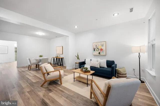 a living room with furniture and a wooden floor