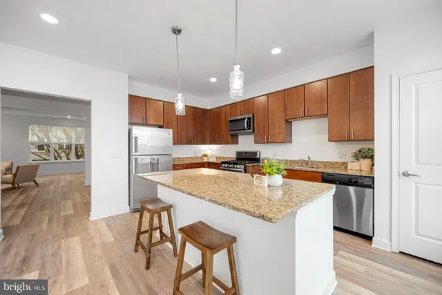 a kitchen with stainless steel appliances granite countertop a sink refrigerator and cabinets