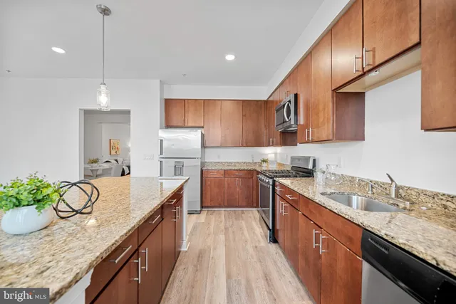 a kitchen with stainless steel appliances granite countertop sink stove and cabinets