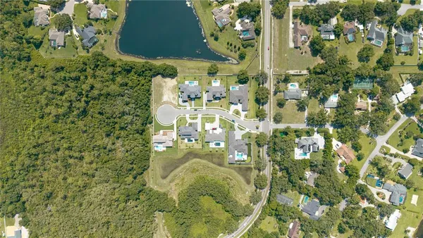 an aerial view of residential houses with outdoor space and swimming pool