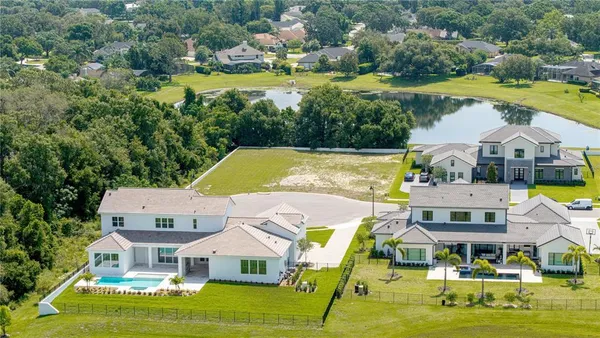 an aerial view of residential houses with outdoor space and lake view