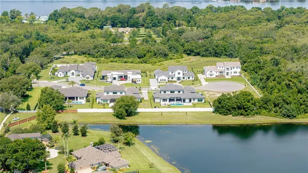 an aerial view of residential houses with outdoor space and river