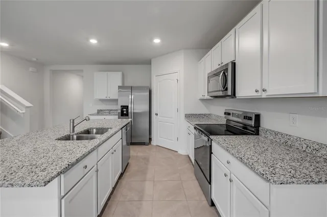 a kitchen with stainless steel appliances granite countertop a sink stove and cabinets