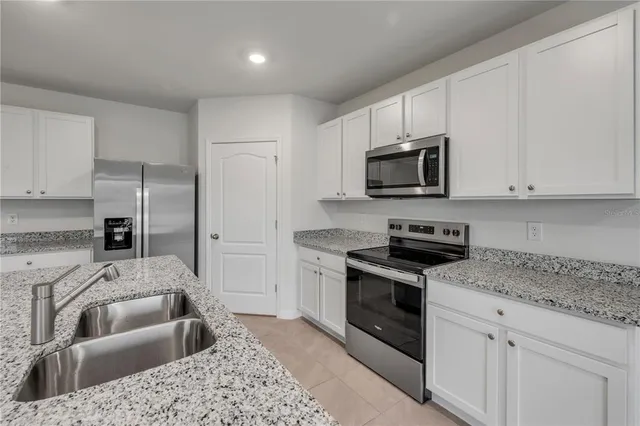 a kitchen with stainless steel appliances granite countertop a refrigerator sink and stove
