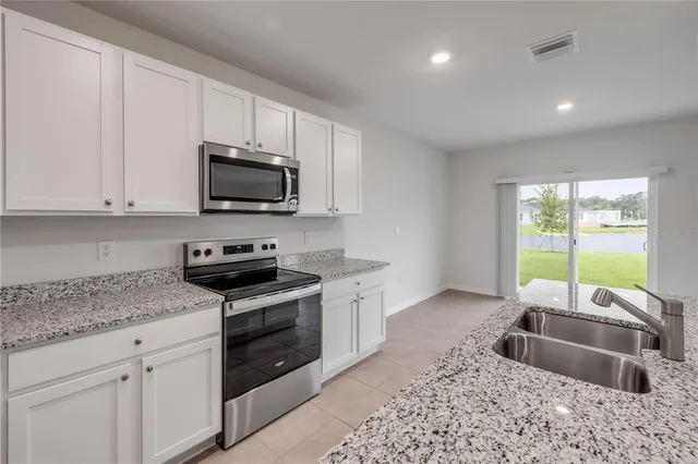 a kitchen with granite countertop a sink and a stove top oven