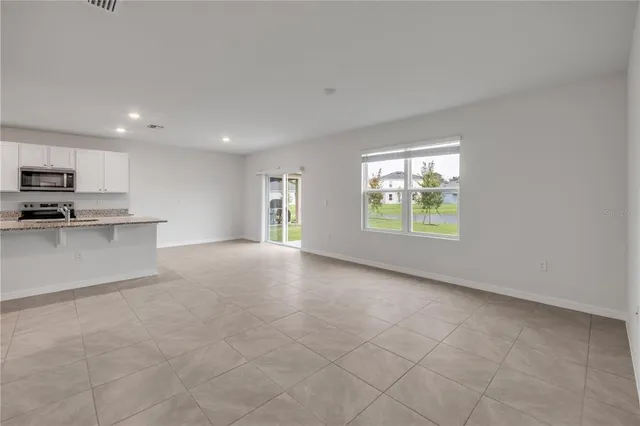 a view of a kitchen with microwave and window