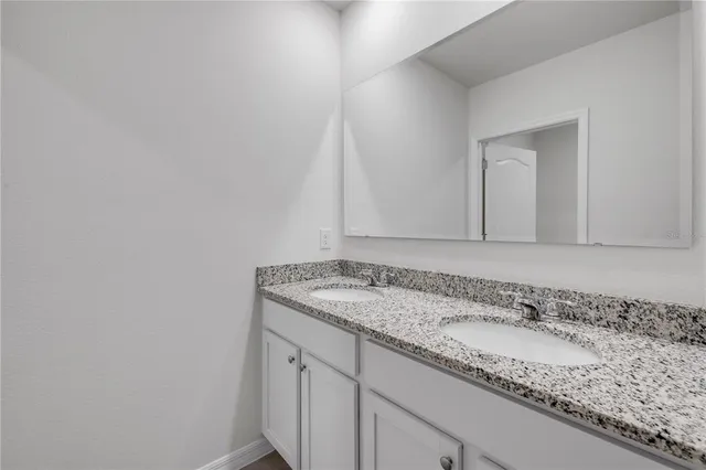 a bathroom with a granite countertop sink and vanity