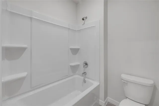 a white bath tub sitting next to a white toilet