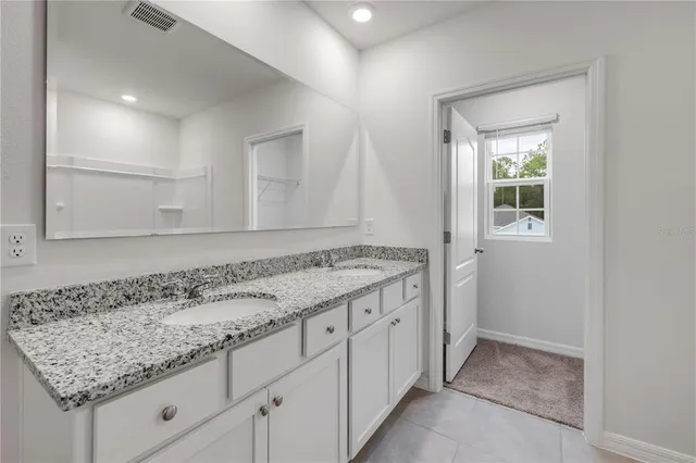 a bathroom with a granite countertop sink and a mirror