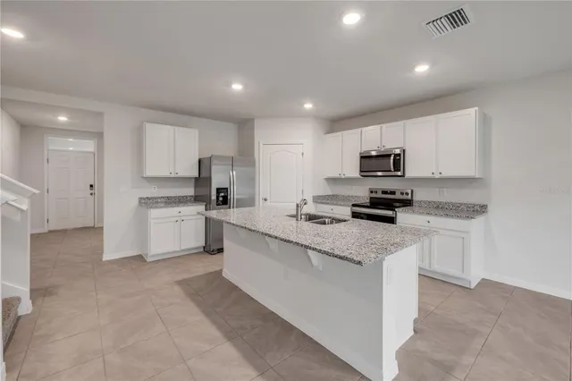 a kitchen with granite countertop white cabinets and white appliances