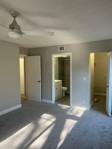 a view of a bedroom with a furniture and a ceiling fan