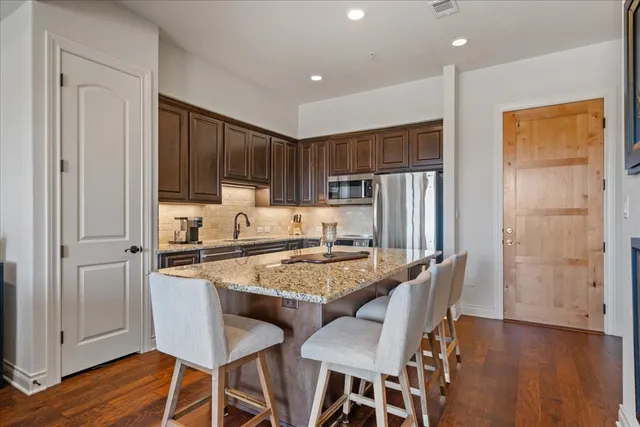 a kitchen with granite countertop a sink cabinets and wooden floor