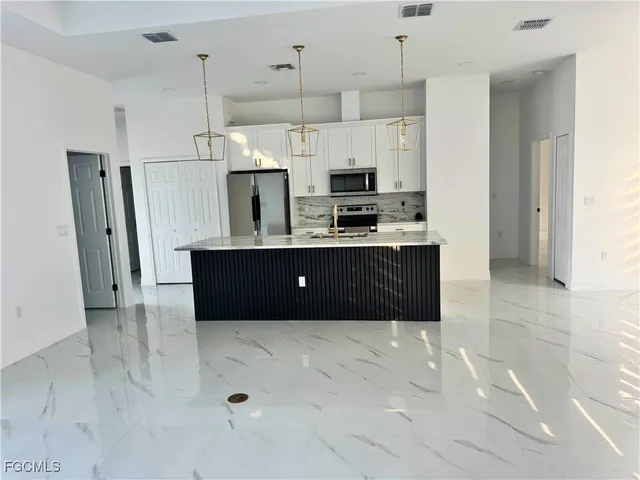a large kitchen with cabinets and stainless steel appliances