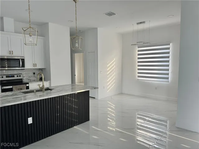 a kitchen with stainless steel appliances granite countertop a sink a stove and a refrigerator