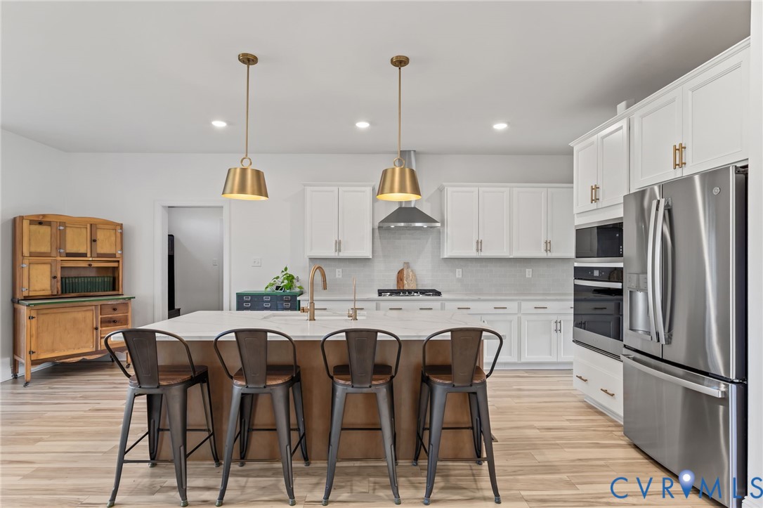 4700 Melbrook Way Moseley, VA 23120 - Photo 12 of 58 a kitchen with stainless steel appliances a dining table chairs refrigerator and microwave