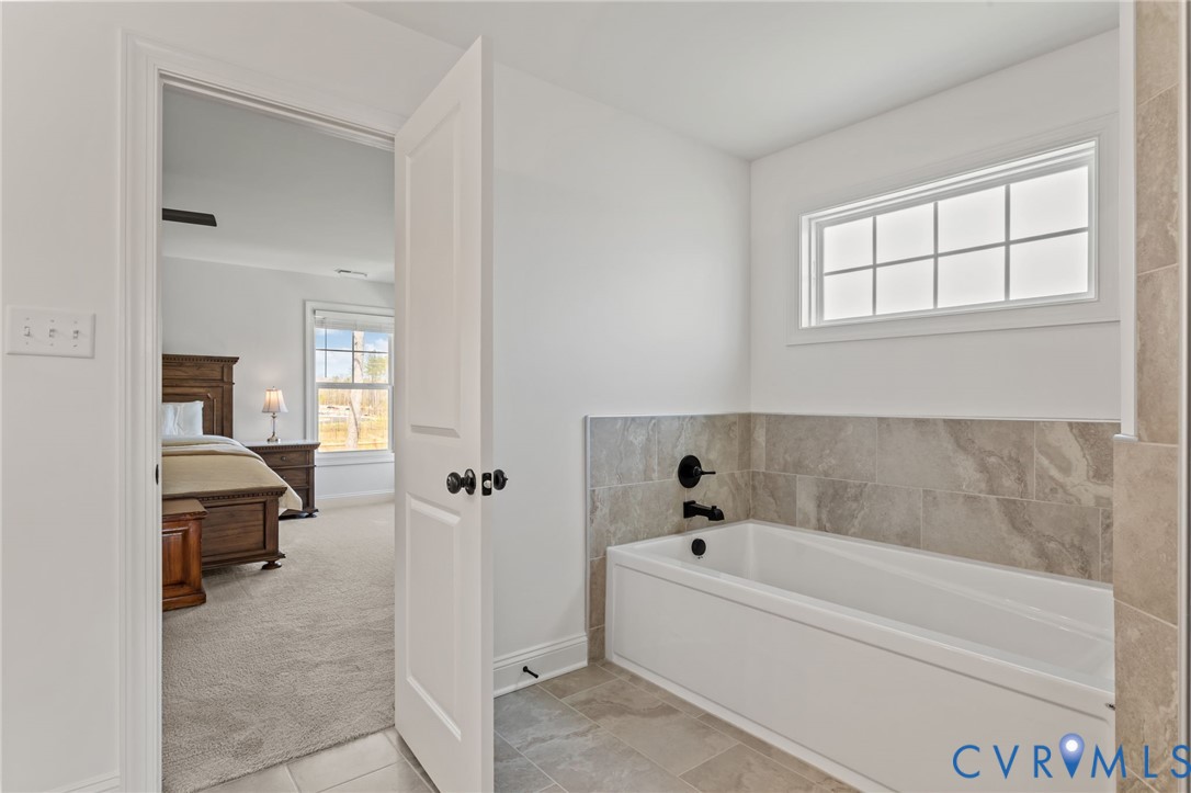 4700 Melbrook Way Moseley, VA 23120 - Photo 31 of 58 a bathroom with a tub and a view of living room