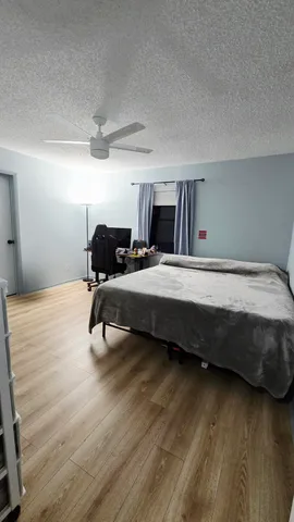 a bedroom with a bed and wooden floor