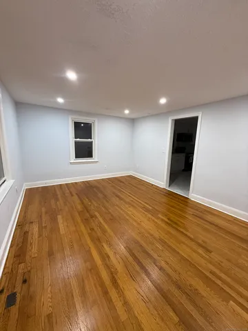 a view of empty room with wooden floor