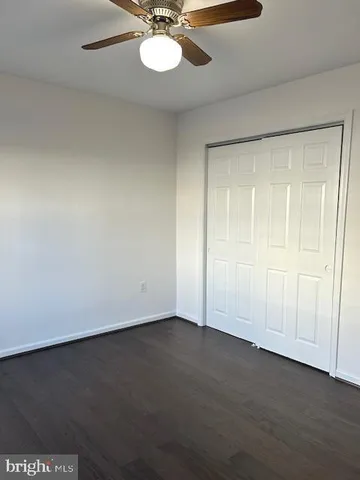 an empty room with a ceiling fan and a window
