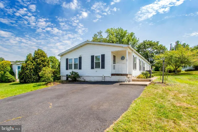 a front view of a house with swimming pool and porch with furniture