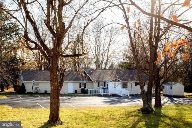a front view of a house with swimming pool and trees