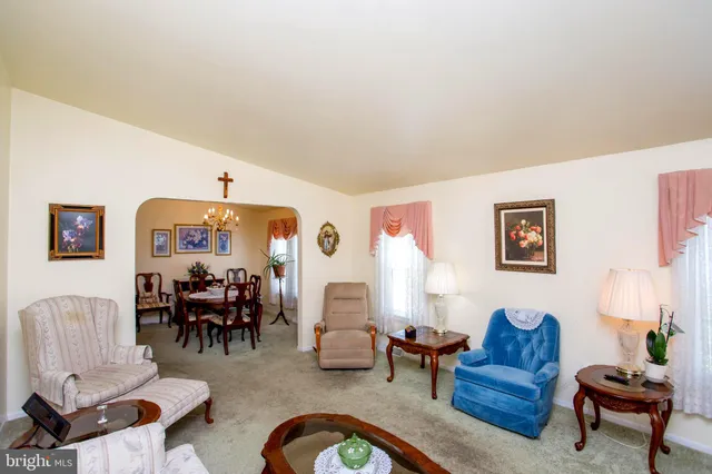 a living room with furniture and a dining table with rug