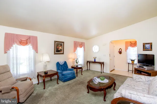 a living room with furniture a window and a flat screen tv