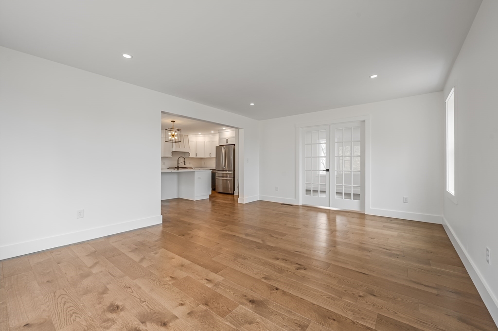 36 Belvidere Road Haverhill, MA 01830 - Photo 7 of 18 a view of an empty room with wooden floor and a kitchen