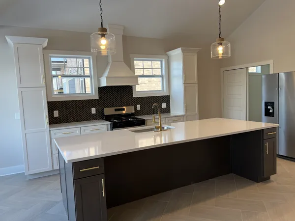 a kitchen with a refrigerator a sink dishwasher a dining table and chairs