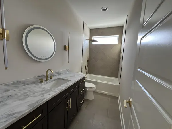 a bathroom with a granite countertop sink toilet and shower