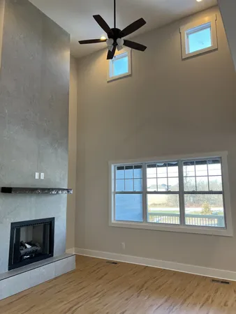 a view of an empty room with a window and fireplace