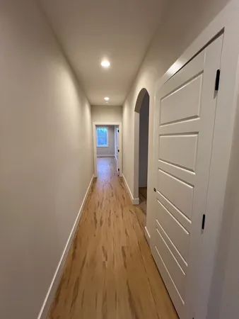 a view of a hallway with wooden floor
