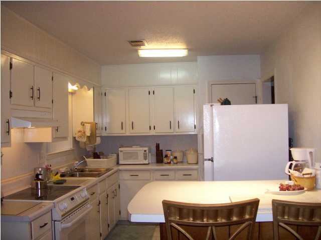235 Deluna Road Southwest Fort Walton Beach, FL 32548 - Photo 4 of 24 a kitchen with a table chairs stove and cabinets