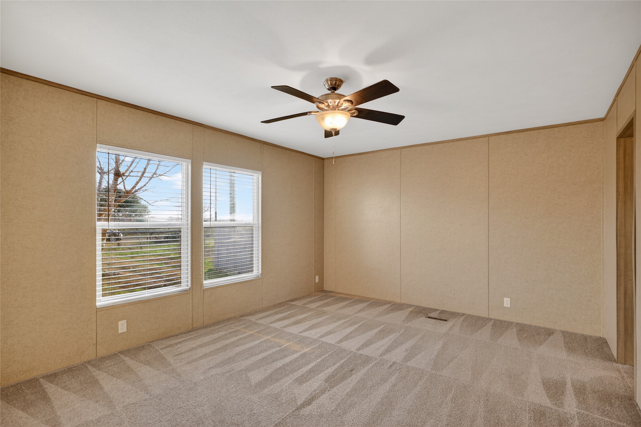 2674 Cotton Gin Road Kyle, TX 78640 - Photo 17 of 30 Unfurnished room featuring light carpet, ceiling fan, a decorative wall, and crown molding