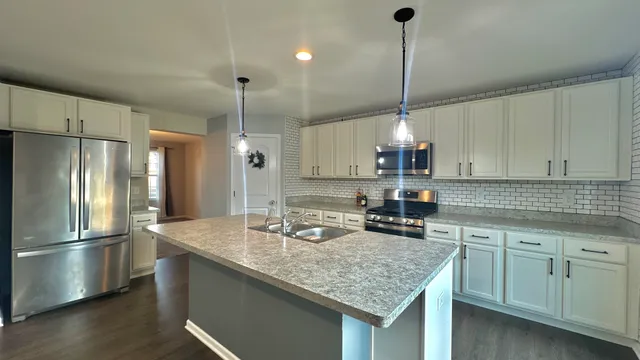 a kitchen with center island cabinets and stainless steel appliances