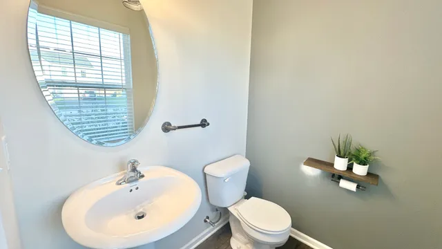 a bathroom with a sink a toilet and a mirror
