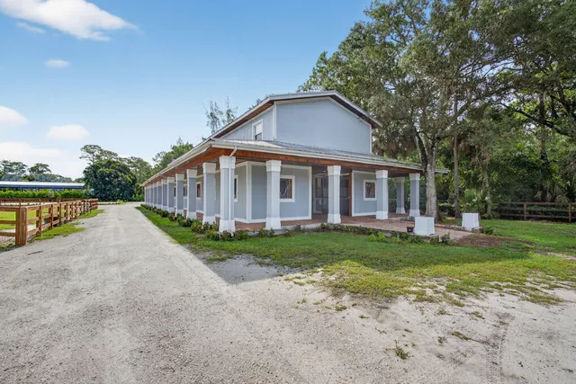 a front view of a house with porch and garden