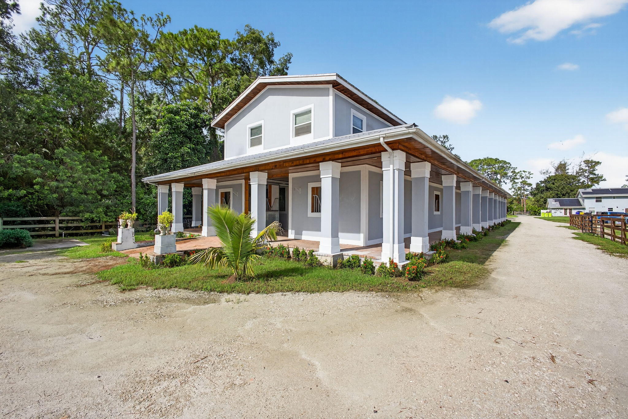1032 Hyde Park Road Loxahatchee Groves, FL 33470 - Photo 18 of 30 a front view of a house with porch and garden