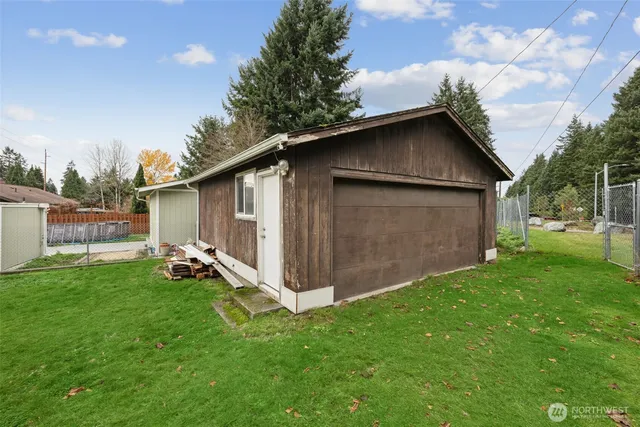 a view of backyard with barbeque grill and wooden fence
