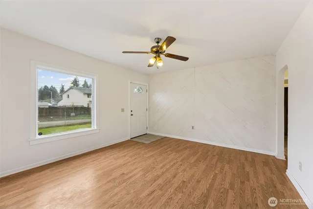 an empty room with a window and a ceiling fan