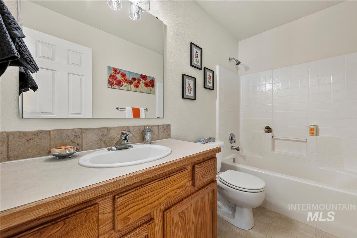 2356 West Hill Road Boise, ID 83702 - Photo 20 of 22 Wood-finish vanity with a light-toned countertop, integrated sink, and a large mirror