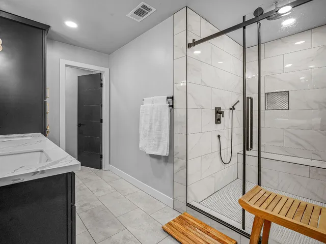 a bathroom with a sink a mirror a toilet and a shower