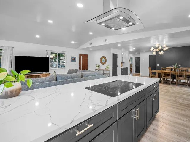 a kitchen with stainless steel appliances granite countertop a stove a sink dishwasher and a refrigerator with wooden floor